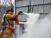 Fireman spraying fire extinguisher